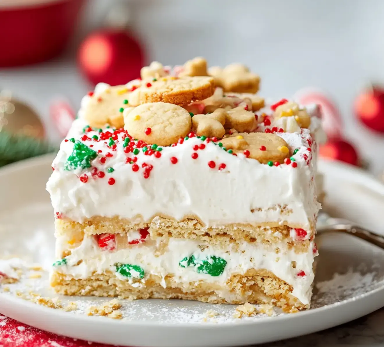 A cheerful layered dessert with cream, colorful sprinkles, and fun cookie toppers sits ready on a plate.